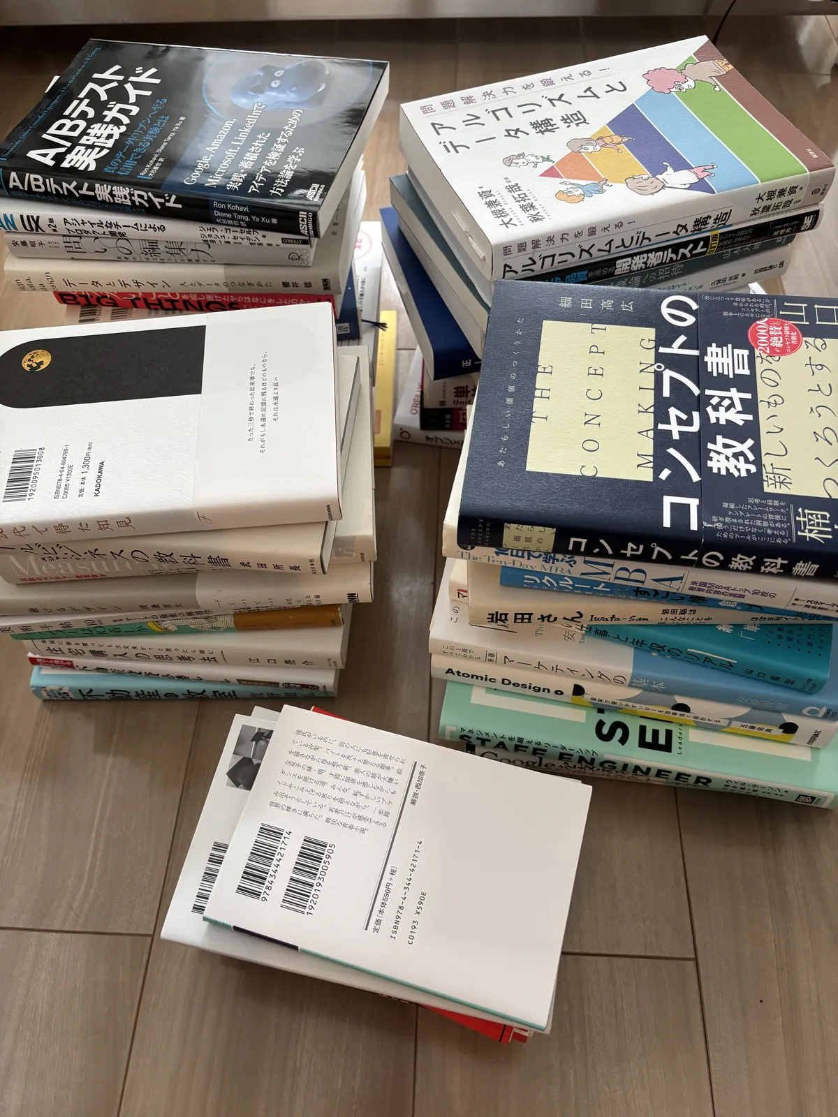 床に複数の山に分けて積んだ処分候補の書籍